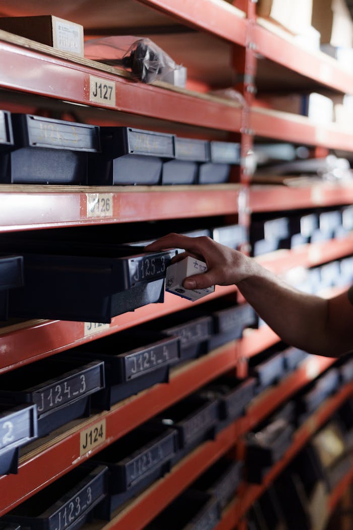 services-02 Hand reaching for storage bin in organized warehouse shelving. Perfect for logistics and inventory themes.